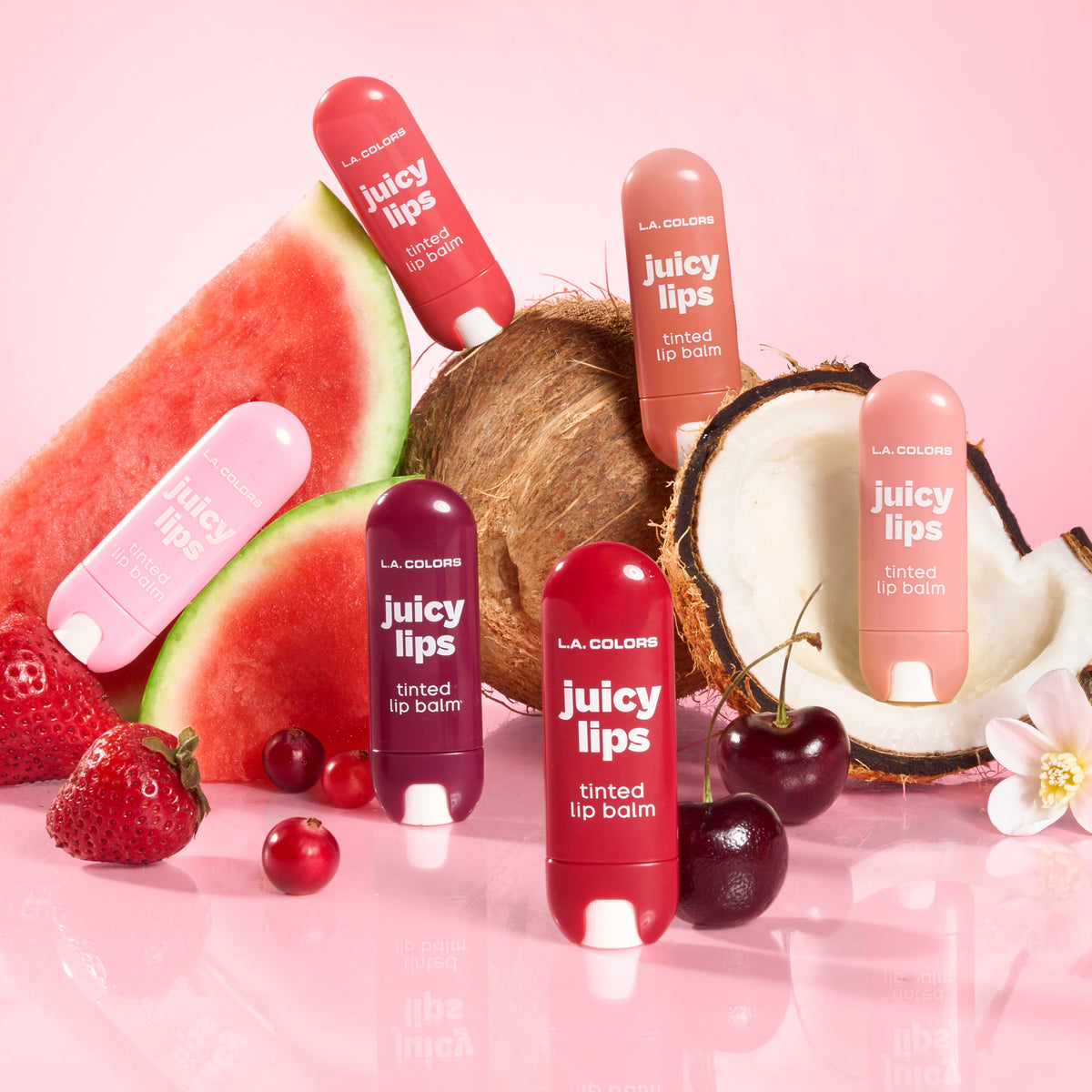 Six shades of Juicy Lips Tinted Lip Balm displayed with watermelon, coconut, strawberries, and cherries